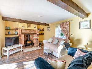 a living room with a couch and a fireplace at The Barn in Ropsley