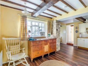 a kitchen with a wooden dresser and a chair in a room at The Barn in Ropsley