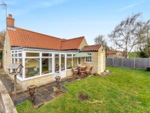 a house with a patio and a yard at The Barn in Ropsley