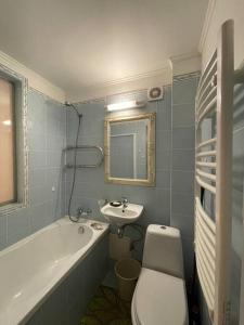 La salle de bains est pourvue d'un lavabo, de toilettes et d'une baignoire. dans l'établissement Апартаменты, Юрмала, à Jurmala