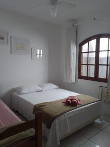 1 dormitorio con 2 camas y ventana en Ramos Acomodações, en Búzios