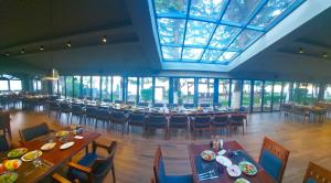 un ristorante con tavoli e sedie e un grande soffitto in vetro di Hotel Cami a Debar