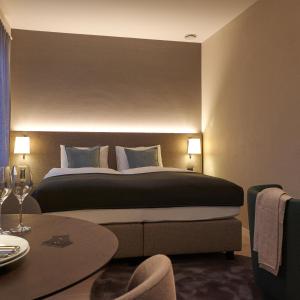 ein Hotelzimmer mit einem großen Bett und einem Tisch in der Unterkunft CITY STAY - Franklinstrasse in Zürich