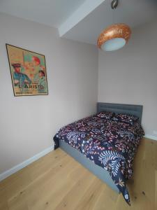 ein Schlafzimmer mit einem Bett mit einer Bettdecke darauf in der Unterkunft Belle maison indépendante 4 pers avec terrasse in Rueil-Malmaison