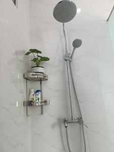 a shower in a bathroom with two shelves at Song Trân House in Xã Tân Phát