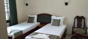 two twin beds in a room with green curtains at Elim Homestay Fort Kochi in Cochin