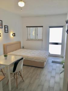 a bedroom with a bed and a table and a desk at Villa Marias - Ferragudo in Ferragudo