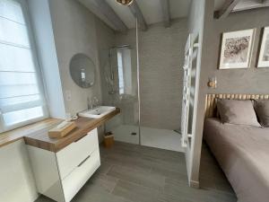 a bathroom with a bed and a sink and a shower at Gîte La Patouille in Amboise