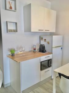 uma cozinha com armários brancos e um frigorífico branco em Villa Marias - Ferragudo em Ferragudo