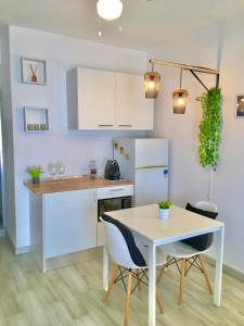 uma cozinha com armários brancos e uma mesa e cadeiras em Villa Marias - Ferragudo em Ferragudo