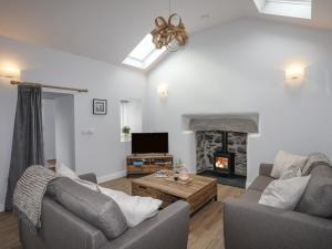 sala de estar con 2 sofás y chimenea en Tan Y Coed - Nasareth en Caernarfon