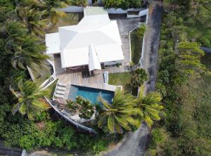 an aerial view of a white house with a swimming pool at Villa Vue Océan in Le Moule
