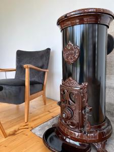 a wooden stove in a room with a chair at Holiday House Randu Pļavas in Salacgrīva