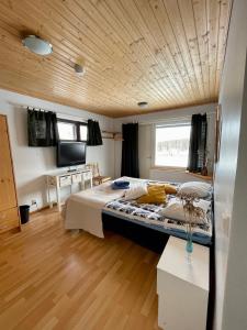 Cama grande en habitación con techo de madera en Lamminmäen Juhla ja Peti en Joutsa