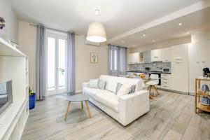 ein Wohnzimmer mit einem weißen Sofa und einer Küche in der Unterkunft Stella House in Desenzano del Garda