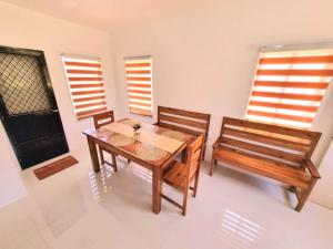 a dining room with a wooden table and two benches at Palawan two bedroom home in puerto princesa city in Puerto Princesa City