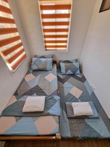 a attic bedroom with two beds and a window at Palawan two bedroom home in puerto princesa city in Puerto Princesa City