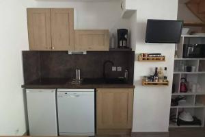 a kitchen with a white refrigerator and a dishwasher at Appartement duplex au pied des pistes in Le Dévoluy