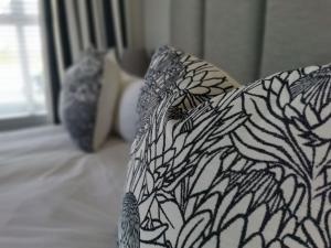 a white couch with a black and white pattern at Huis van Brood Guesthouse in Malmesbury