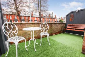 a patio with two chairs and a table and a bench at Modern, stylish city centre 3 bed property sleeps 6 in Lincoln