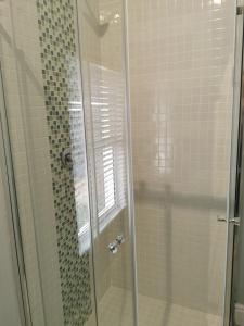 a bathroom with a shower with a glass door at Huis van Brood Guesthouse in Malmesbury