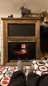 a person sitting on a bed in front of a fireplace at B&BTorre Cives in Vidracco