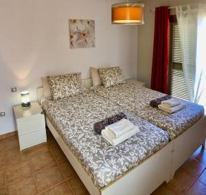 a bedroom with a large bed with towels on it at Villa Irina in Caleta De Fuste +20 photos