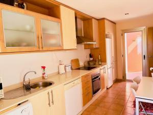 a kitchen with wooden cabinets and a sink at Villa Irina in Caleta De Fuste