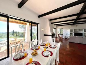 a dining room with a white table and a large window at Portimão Bellevue Villa With Pool by Homing in Portimão