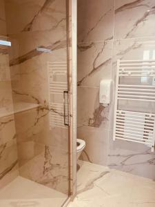 a bathroom with a glass shower with a toilet at Hotel Restaurant de la Tour in Sanary-sur-Mer