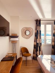 Schlafzimmer mit einem Bett, einem Schreibtisch und einem Stuhl in der Unterkunft Hotel Restaurant de la Tour in Sanary-sur-Mer