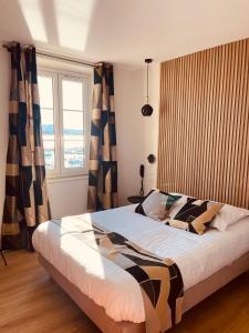 a bedroom with a large bed and a window at Hotel Restaurant de la Tour in Sanary-sur-Mer