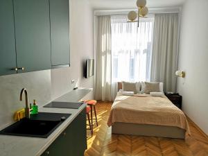 - une cuisine avec un lit et un évier dans la chambre dans l'établissement Unique Style Apartments Old Town - 25 min from the airport - by Homelike Krakow, à Cracovie