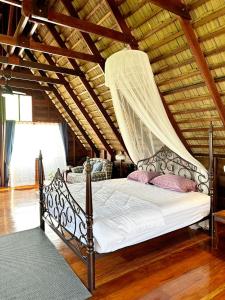 a bedroom with a bed with a mosquito net at RuenKijja in Ban Kroen