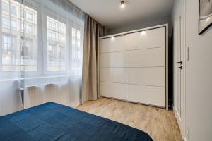 1 dormitorio con 1 cama y armario blanco grande en Apartamenty Dąbrowskiego MODERN CITY en Katowice