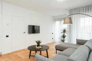a living room with a couch and a table at 26 Bricks Suites in Oradea