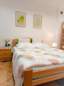 una camera con un letto e un comodino e due immagini di ODMORKO Zemun a Belgrado