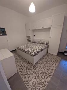 ein weißes Schlafzimmer mit einem Bett und einem Teppich in der Unterkunft Casa di Nico in Finale Ligure