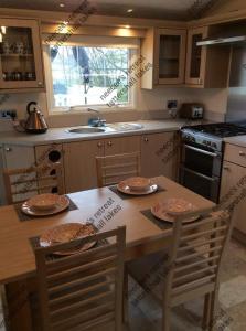 a kitchen with a wooden table with chairs and a stove at Neecee’s Retreat in Tattershall