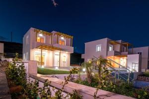 a large white house at night with lights at Villa Regina - Double Pool Paradise in Lachania
