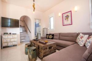 a living room with a couch and a table at Villa Regina - Double Pool Paradise in Lachania +26 photos
