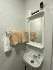 a bathroom with a sink and a mirror and towels at Sweet Loft Homestay in Johor Bahru
