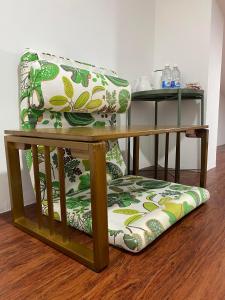 a green and white chair with a cushion on a wooden floor at Sweet Loft Homestay in Johor Bahru