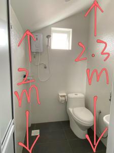 Baño con escritura roja en la pared en Sweet Loft Homestay en Johor Bahru