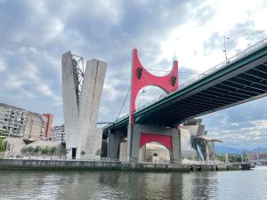 a bridge over a river next to a city at Uribarri Home Bilbao in Bilbao