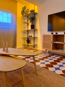 sala de estar con mesa y TV de pantalla plana en Apartamento PC, en Torrelavega