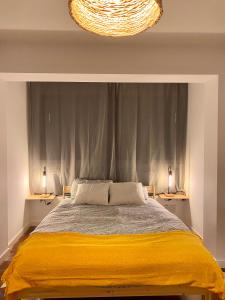 um quarto com uma cama com um cobertor amarelo em Apartamento PC em Torrelavega