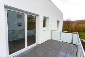 einen Balkon mit Glastüren in einem weißen Gebäude in der Unterkunft Große COZY 3-Zi-Whg mit Balkon Nähe Europa Park und Rulantica in Lahr-Dinglingen