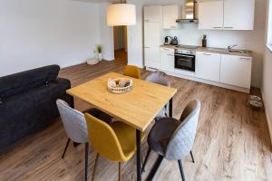 a kitchen and living room with a wooden table and chairs at Große COZY 3-Zi-Whg mit Balkon Nähe Europa Park und Rulantica in Lahr