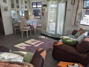 ein Wohnzimmer mit einem Sofa und einem Tisch in der Unterkunft Ferny Roost Cabin. in Wrexham
